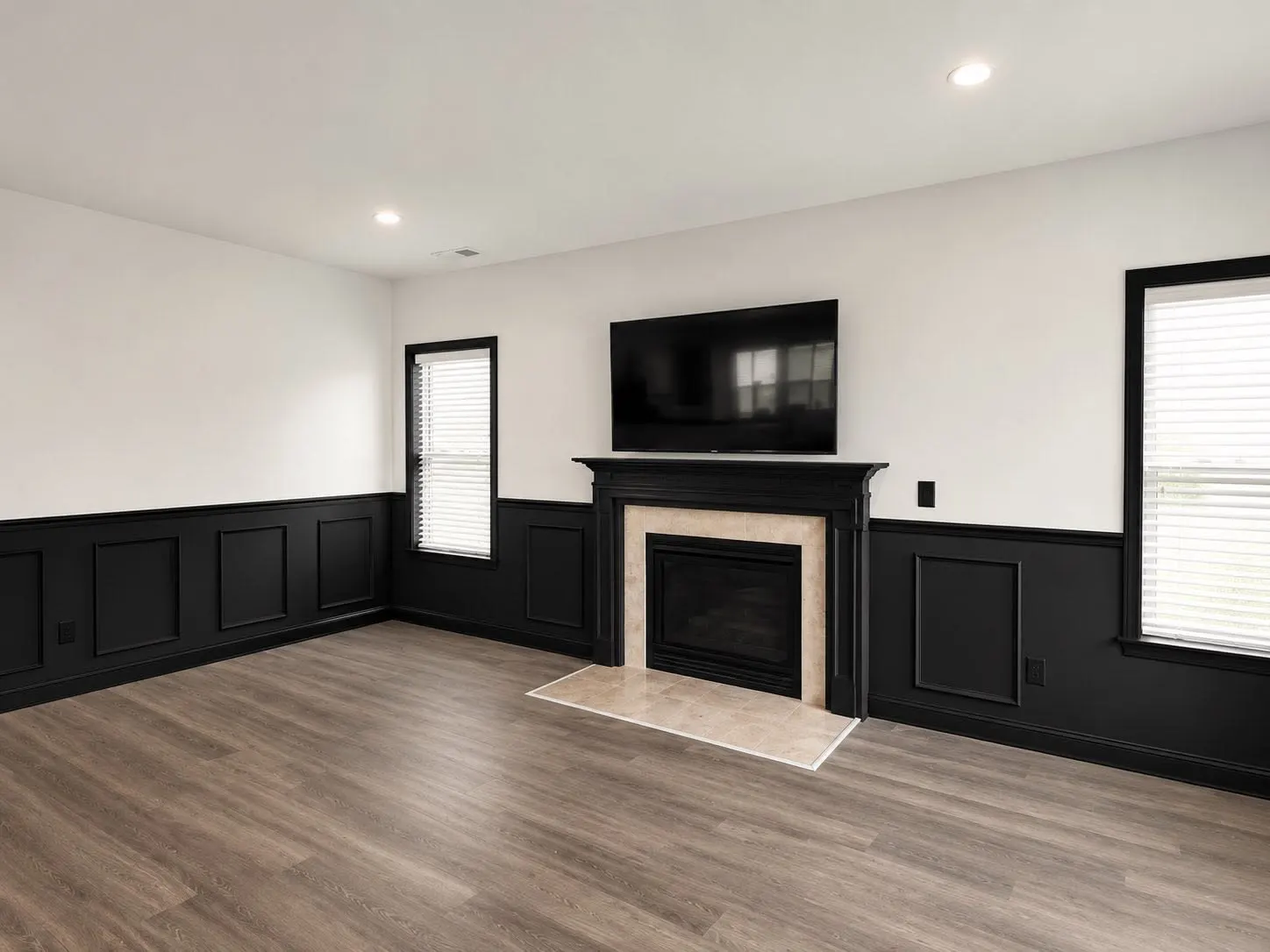 Finished living room interior with dark painted wainscoting and white walls