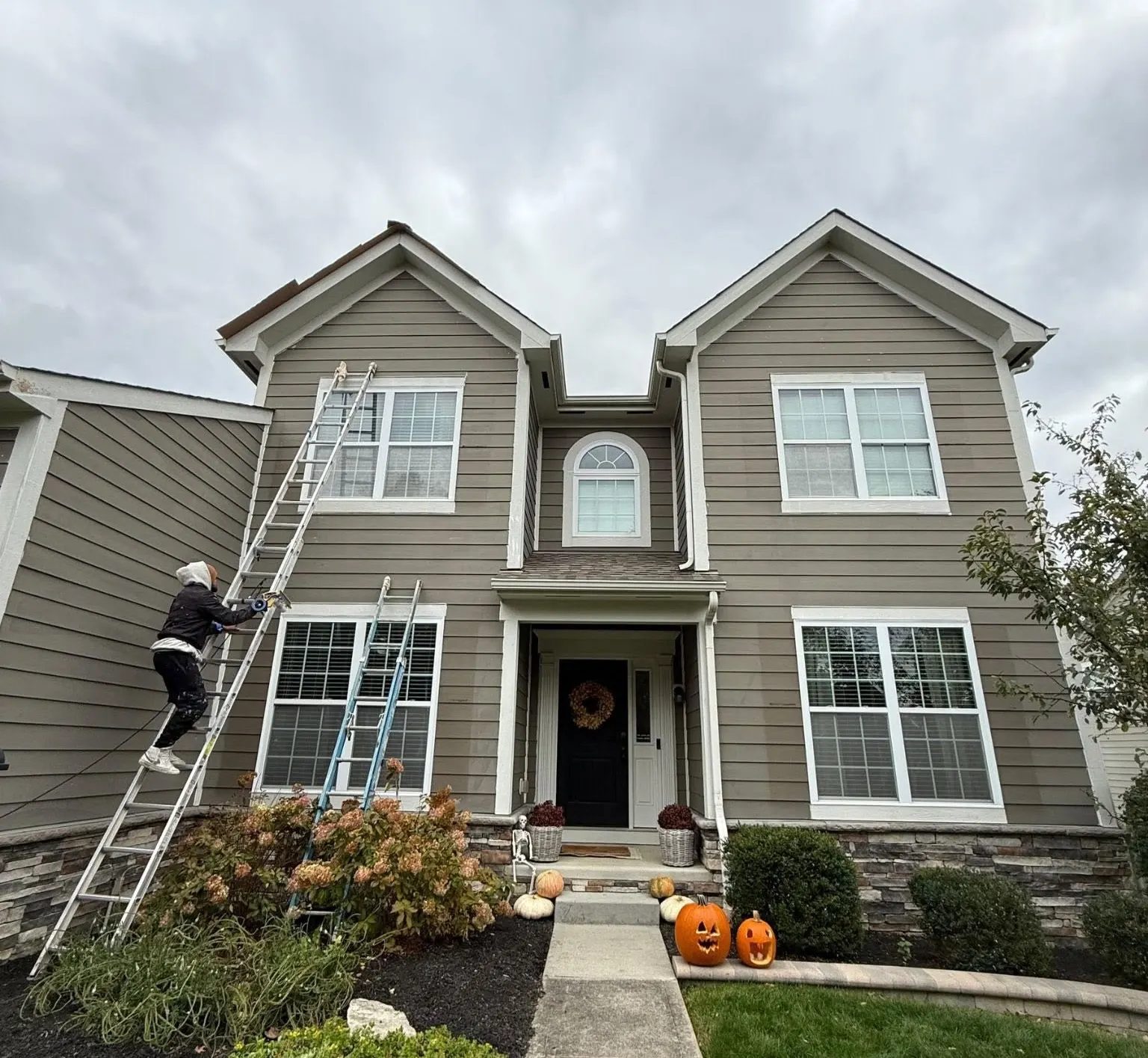 Professional exterior house painter working on residential siding
